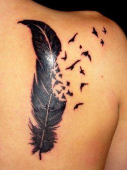 A black ink tattoo of a feather turning into a flock of birds