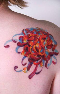 An Amanda Washob abstract tattoo of goldfish emerging from a swarm of color