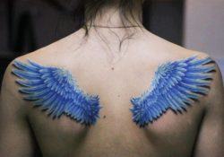 A tattoo of blue angel wings on the back with the feathers of birds wings