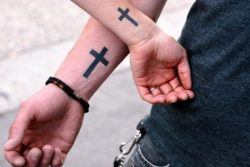 A young Christian couple celebrate their religion and relationship with matching cross tattoos