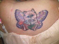 A cute cartoon tattoo of a kitten with butterfly wings holding a daisy flower
