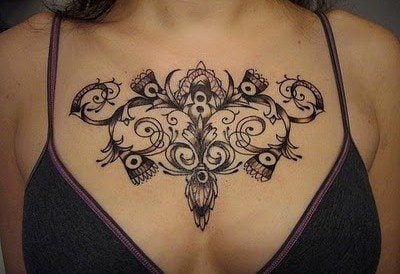 A feminine chest tattoo decorates this woman cleavage with flowers and vines