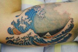 A bicep tattoo of the famous Japanese wave tattoo design based on the 19th century illustration by Hokusai