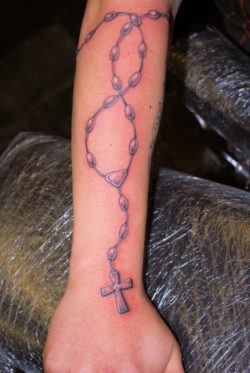 A rosary beads tattoo design gives this person a piece of permanent religious jewelry
