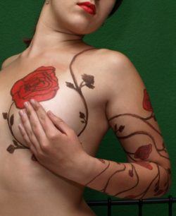 A rambling rose tattoo design has red rose flowers and vines curling around this womans body