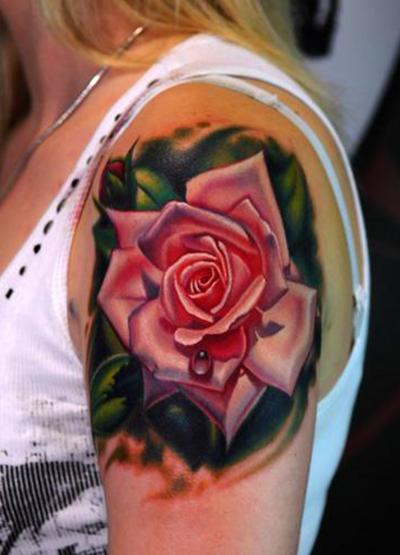 A gorgeous pink rose tattoo decorates this girl's shoulder.