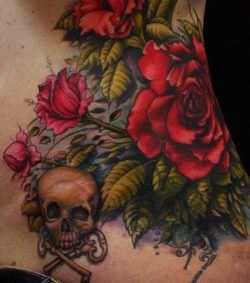 A stunning tattoo of roses and a skull with crossed keys by Scott Trerrotola