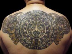 A tattoo of the Mayan calendar surrounded by mayan serpent tattoos