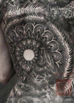 A wolf and a bird hide within a sacred geometry mandala in this Thomas Hooper tattoo design