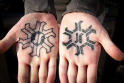 Negative and positive palm tattoo designs in black ink.