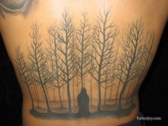 Tattoo of a forest of dead trees. Spooky body art design.