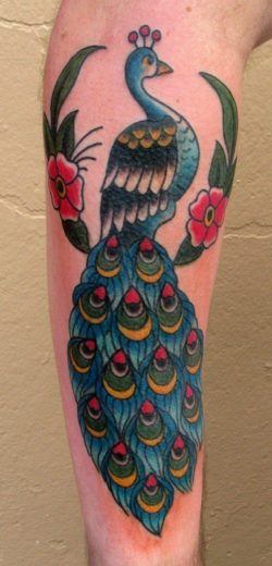 This old school style tattoo depicts a peacock sitting in a tree displaying its colorful feathers