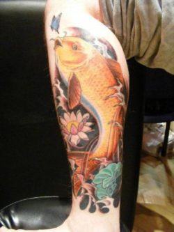 This tattoo combines the symbols of a golden koi carp with a lotus flower, butterfly, lily pad and water.