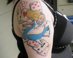 An Alice in Wonderland tattoo that shows the Walt Disney Alice character surrounded by playing cards