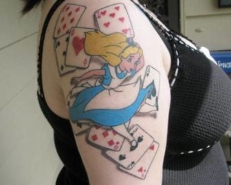 An Alice in Wonderland tattoo that shows the Walt Disney Alice character surrounded by playing cards