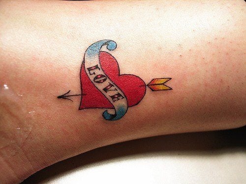 This cute love tattoo shows a heart with cupid's arrow through it