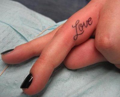 A tattoo of the word love on the inside of this woman's ring finger, the finger that symbolizes love