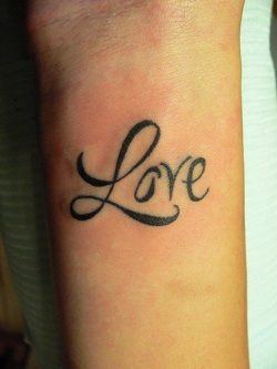 The word love is tattooed onto this girl's wrist in a clear but fancy font.