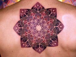 The pattern of curved lines appears almost animated, giving this flower mandala tattoo a lively appeal