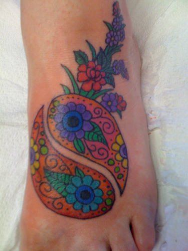 This colorful yin yang tattoo uses paisley and floral patterns to create the yin yang symbol