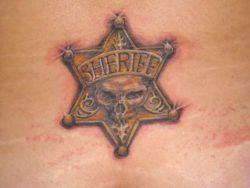 This unusual star tattoo combines the symbols of a sheriff's badge and a human skull