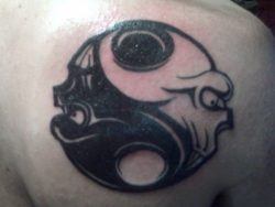 This tattoo design uses two human skulls to create the balanced halves of the yin yang design