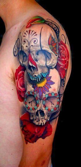 A Day of the Dead tattoo of two sugar skulls on a bed of roses