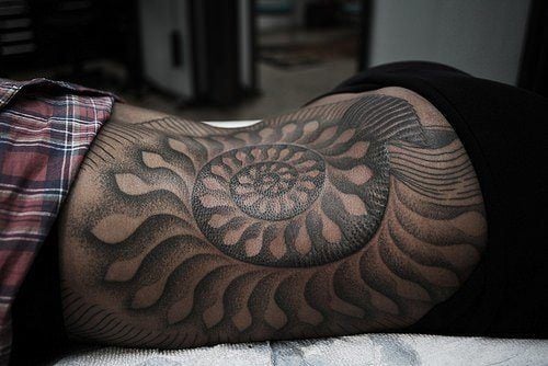 A Thomas Hooper tattoo of a nautilus shell. Even in black ink, the trippy nature of the nautilus is apparent