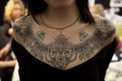 A beautiful lace collar tattoo that uses hearts and roses to symbolize love and passion
