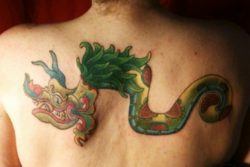 A colorful tribal tattoo of the Aztec god Quetzalcoatl as a feathered serpent