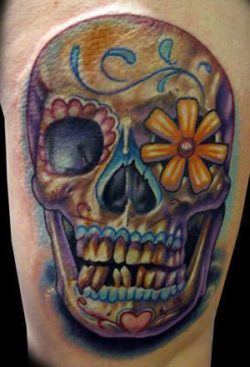 A grinning sugar skull tattoo design with a daisy flower in the eye socket