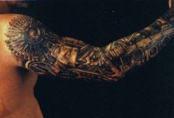 A steampunk tattoo design that creates the illusion that the guys arm is made of mechanical elements