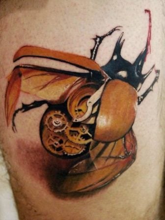A steampunk tattoo of a clockwork scarab beetle with brass mechanical innards