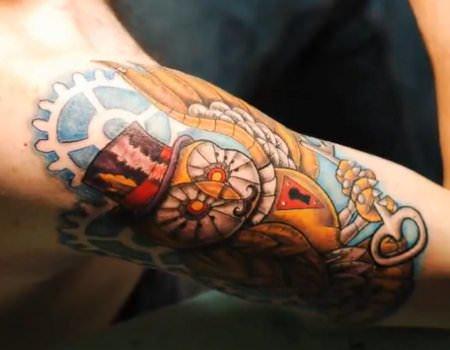 A steampunk tattoo of a key operated clockwork owl with a top hat and monocle