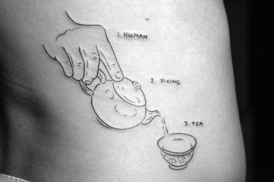A tattoo of a human, yixing tea pot and tea cup decorates this tea lovers body