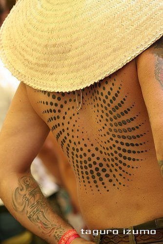 A trippy tattoo design of a spiralling vortex of circles, seen at an outdoor trance party