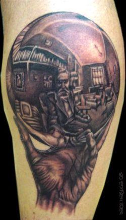 An optical illusion tattoo of MC Escher drawing his own reflection in a silver ball