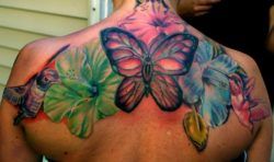 Hummingbirds, hibiscus flowers and a butterfly make up this colorful, feminine tattoo design
