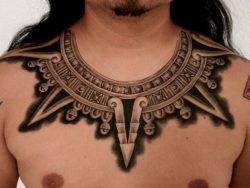 This tattoo collar decorates this guys neck and chest with tribal Aztec architectural elements