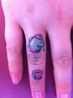 Two tiny tattoos of a tea pot and a tea cup make a cute finger tattoo design