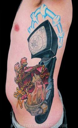 A cartoon graffiti tattoo by Jesse Smith of a character with a TV for a head holding a chrystal heart wrapped in chains