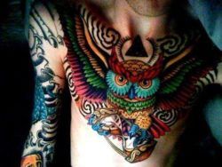A colorful and creative bird tattoo of an owl holding an hourglass symbolizing wisdom and time