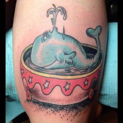 A fun tattoo of an illustration by Dr Seuss of a whale in a circus