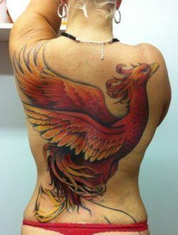 A large tattoo of a phoenix covers this girls back in a powerful symbol of strength and the ability to rise above