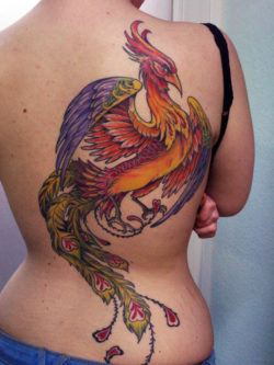 The gold, red and purple inks used in this phoenix tattoo add to the mystical nature of the fire bird