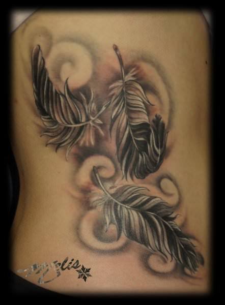 Three feathers are blown by the winds of fate in this feather tattoo design