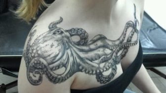 A black and white tattoo of an octopus adorns this girls chest and shoulders
