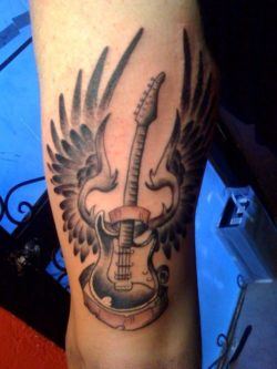 A guitar tattoo design with wings, symbolizing the sense of freedom found in music