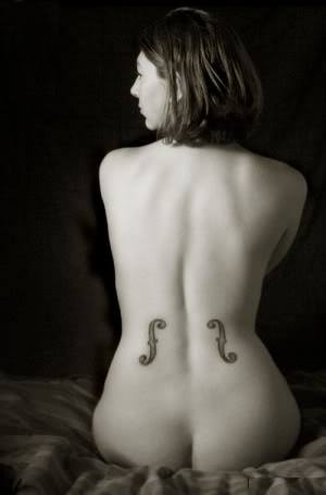 This artistic music tattoo transforms this girls body into a musical instrument by suing the f holes from a guitar