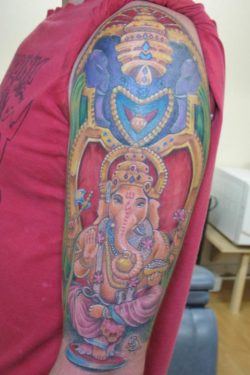 In this tattoo design Ganesh is depicted as having pink skin tones. Other popular colors are blue and green.